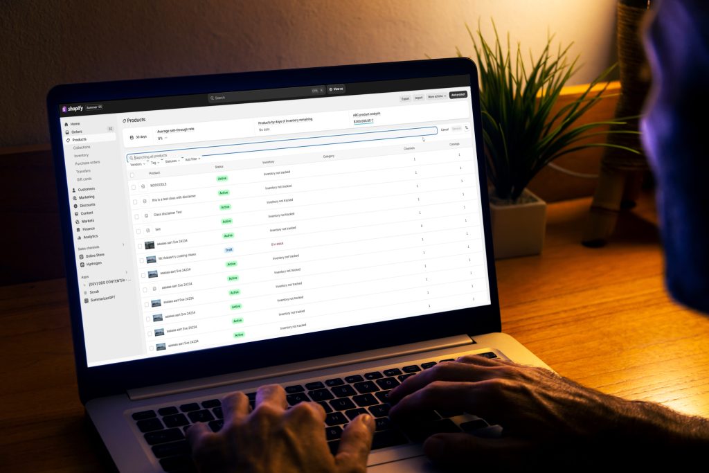 Over shoulder view of man using laptop with a Shopify store open