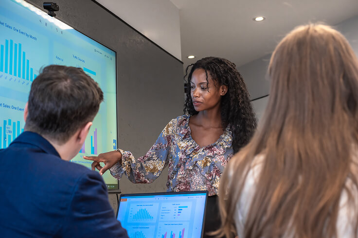 woman presenting charts to two people