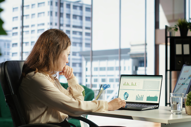 Woman looking seated looking at a laptop screen